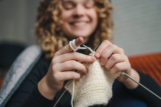 Happy young woman knitting